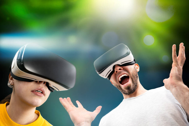 Emotionele mensen met een virtual reality bril. Heldere groene achtergrond met licht. Het concept van virtual reality en moderne technologieën. - Foto, afbeelding