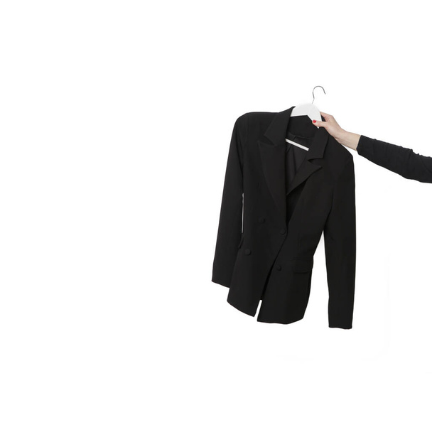 Чёрный двубортный пиджак, висящий на коатангере, изолированном на белом фоне. Современная женская мода ручной работы высшего качества. - Фото, изображение