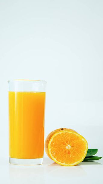 Sumo de laranja 100% fresco num copo e frutas cítricas divididas num fundo branco. Conceito de como viver com uma bebida naturalmente refrescante que contém vitamina C. - Foto, Imagem