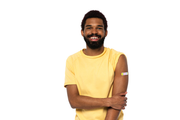 Africano americano com gesso adesivo no braço sorrindo isolado no branco  - Foto, Imagem