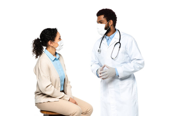 African american doctor in medical mask talking to patient isolated on white  - Valokuva, kuva