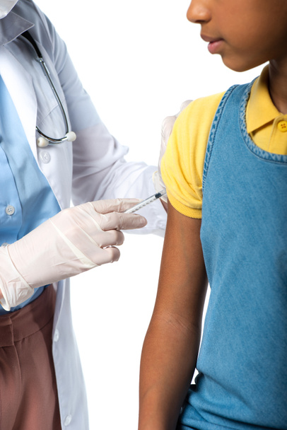 Vista recortada del médico haciendo vacunación de niño afroamericano aislado en blanco  - Foto, imagen