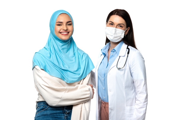 Médecin en manteau blanc et patient musulman souriant à la caméra isolé sur blanc  - Photo, image