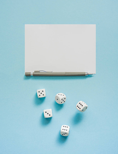 Yahtzee game in progress. Rolling dice, pencil and score sheet on a blue background. - Photo, Image