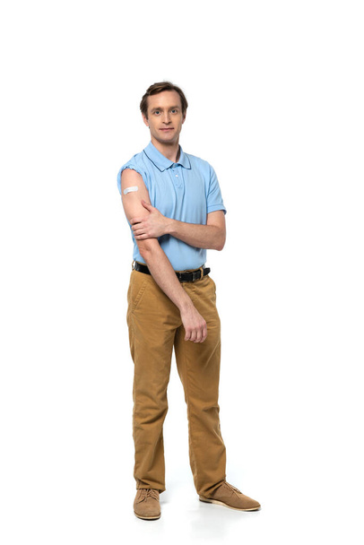 Man with adhesive patch on arm looking at camera on white background  - Fotoğraf, Görsel