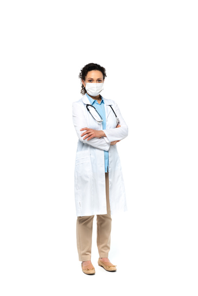 Африканский американский врач в медицинской маске стоит со скрещенными руками на белом фоне  - Фото, изображение