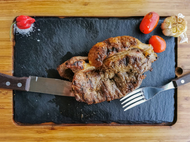 Vue du steak de bœuf grillé avec grand aspect, plat rectangulaire schiste, plat rustique cuisine typique artisanale... - Photo, image