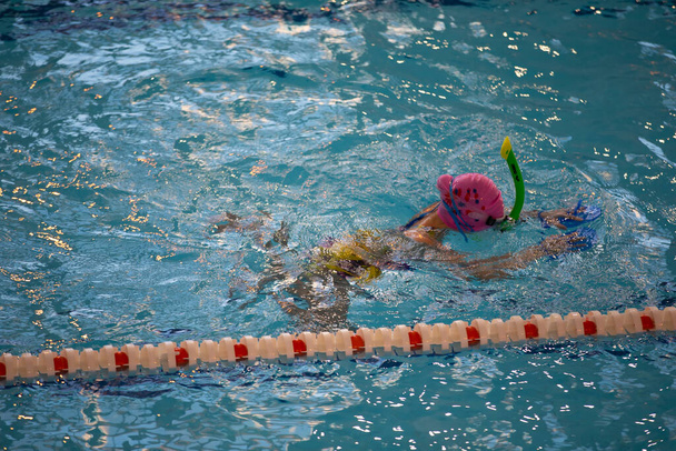 March 10, 2021. Belarus, the city of Gomil. Sports pool. Child athlete swims in the pool. Swimming section. - Photo, Image