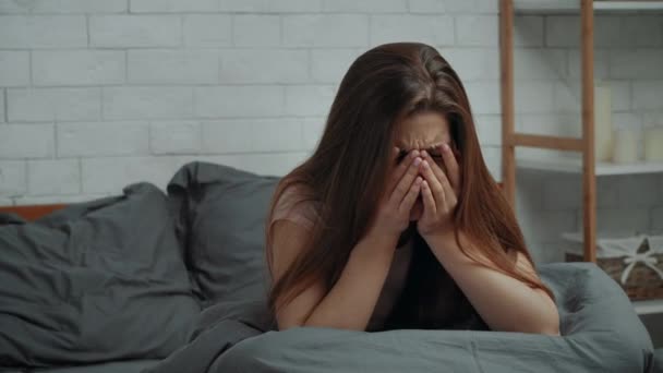 Zdesperowana Pani płacząca cierpiąca na depresję w sypialni w domu - Materiał filmowy, wideo