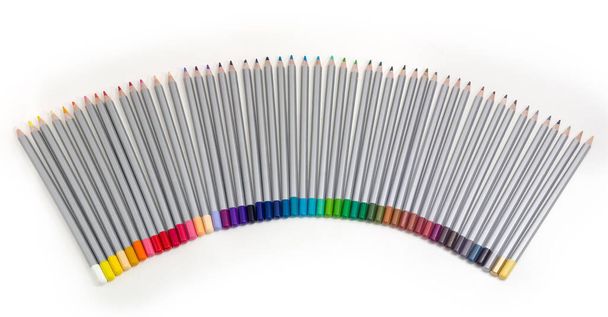 Conjunto de lápis de madeira coloridos pintados de cinza dispostos em um semi-ventilador sobre um fundo branco, vista superior - Foto, Imagem