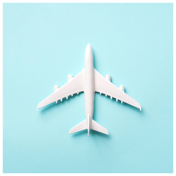 Travel, vacation concept. White model airplane on pastel blue color background with copy space. Top view. Flat lay. Minimal style design. Square crop - Zdjęcie, obraz