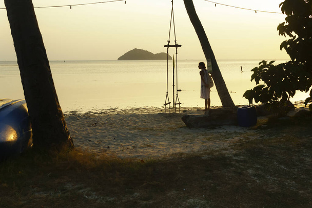 Pôr-do-sol dourado na praia. Vista horizontal com árvores e pessoas.  - Foto, Imagem