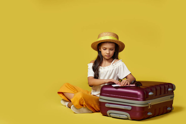 little girl with suitcase and passport sitting on floor - Fotoğraf, Görsel