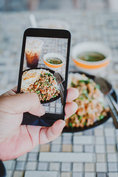 mies käsi ottaa Thai ruoka valokuva matkapuhelimella. Ruokavalokuvausta. Jaa ruokavalokuvausta. Suosittu ruoka kuva - Valokuva, kuva