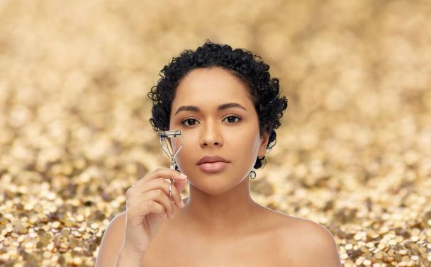 african american woman with eyelash curler - Zdjęcie, obraz