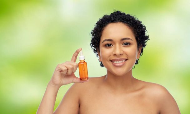 happy african american woman with bottle of serum - Foto, Imagem