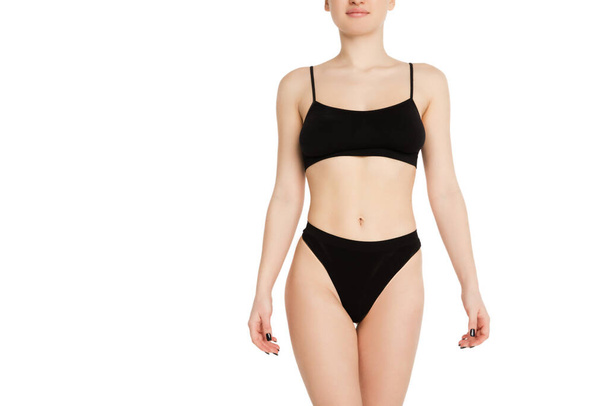 Beautiful female body in black underwear over light background. - Foto, Imagem