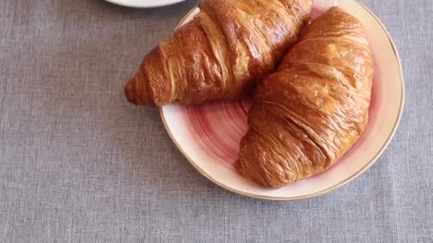 Croissants in a plate on the table and a cup of coffee - Footage, Video