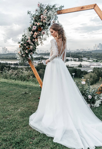 Прекрасная красивая юная стройная невеста в просторном элегантном белом свадебном платье с кружевной улыбкой нежно - Фото, изображение