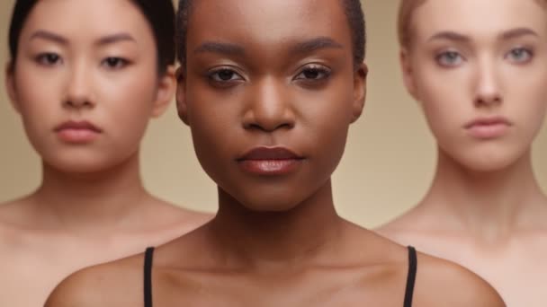 Internationale schoonheid. close-up portret van aziatische, afrikaanse amerikaanse en Kaukasische dames kijken serieus op camera - Video
