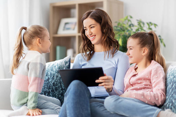 happy mother and daughters with tablet pc at home - Foto, Imagem