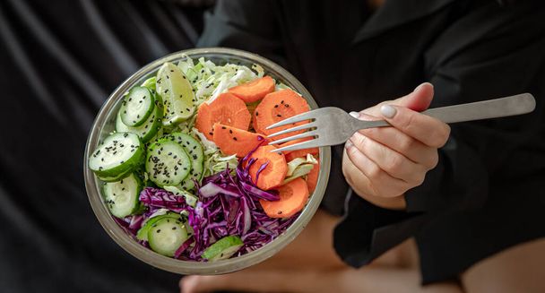 Крупним планом свіжоприготований овочевий салат у жіночих руках
. - Фото, зображення