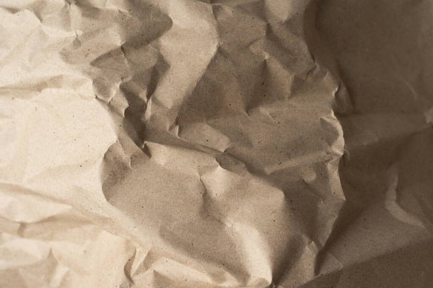 Close-up van gerecycleerde bruine rimpelpapiertextuur voor achtergrond of design of kunstwerk. Bovenaanzicht close-up papieren achtergrond - Foto, afbeelding