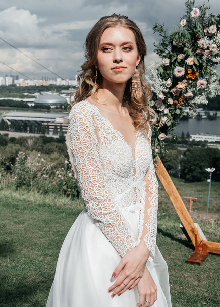 όμορφη όμορφη νεαρή λεπτή νύφη σε ένα ευάερο κομψό λευκό νυφικό με δαντέλα χαμόγελο απαλή - Φωτογραφία, εικόνα