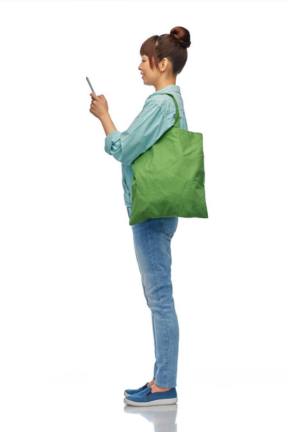 woman with phone and reusable food shopping bag - Foto, imagen