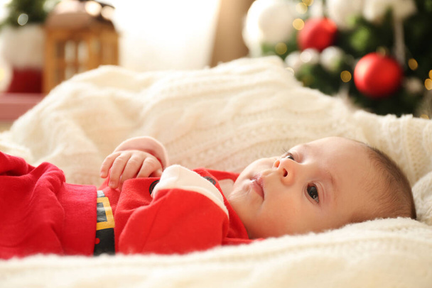Cute little baby on knitted blanket in room decorated for Christmas - Foto, immagini