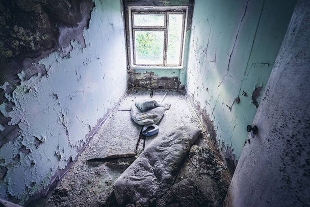 Δωμάτιο ασθενών στο νοσοκομείο της εγκαταλελειμμένης πόλης Pripyat στη ζώνη αποκλεισμού του Τσερνομπίλ, Ουκρανία - Φωτογραφία, εικόνα