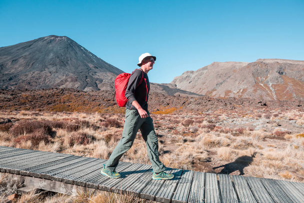 Wędrówki i włóczęgi w Nowej Zelandii. Koncepcja podróży i przygód. mężczyzna piesze wędrówki przez górę Ngauruhoe. - Zdjęcie, obraz