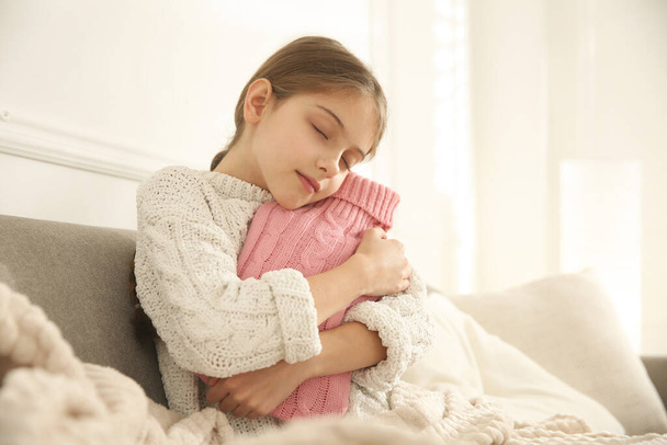 Ill girl with hot water bottle suffering from cold at home - Foto, Imagen