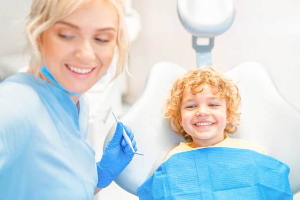 Pretty little boy in dental office, having his teeth checked by female dentist  - Photo, Image