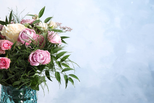 Beautiful bouquet with roses on light blue background, closeup. Space for text - Foto, afbeelding