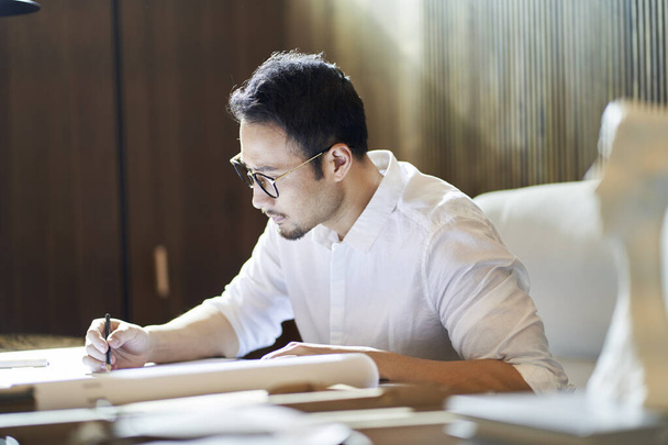 Asian designer in casual wear thinking when working at desk - Photo, Image