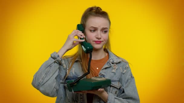Сумасшедшая искренняя девушка-подросток разговаривает по винтажному телефону 80-х годов, дурачится, делает глупые смешные лица - Кадры, видео