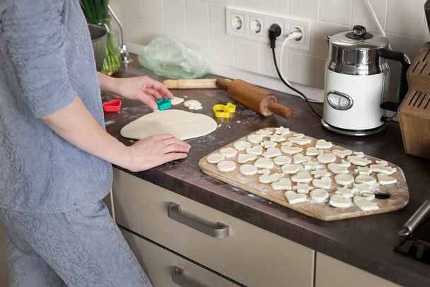 Πορτρέτο νεαρή ενήλικη μελαχρινή καυκάσια γυναίκα κάνει ζύμη με πλάστη για γλυκά νόστιμα σπιτικά μπισκότα στην κουζίνα του σπιτιού. Γυναίκα νοικοκυρά μητέρα μαγείρεμα delicoius υγιεινά χειροποίητα γλυκά - Φωτογραφία, εικόνα