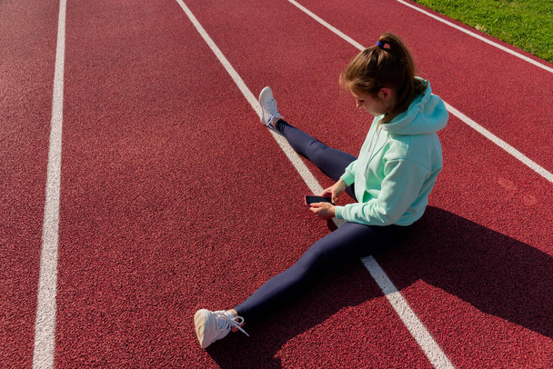 Entrenamiento en la calle, una joven atleta hace un entrenamiento en la plataforma de la calle. - Foto, Imagen