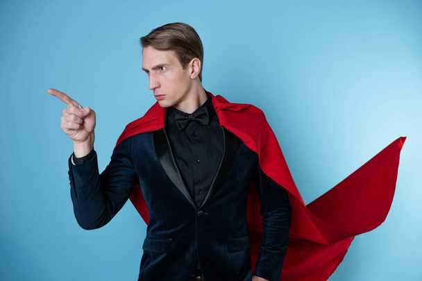 Super man says something important, a hand gesture. Businessman in a suit with a red cape, - Foto, imagen