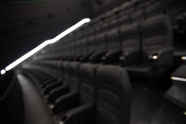 Defocused image of empty black leather seats at movie theater - great entertainment fun background image - Фото, изображение