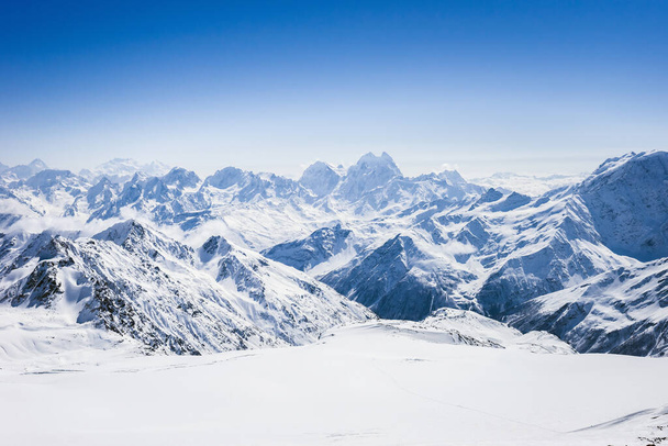 Snowy winter Greater Caucasus mountains at sunny day. View from ski slope Elbrus, Kabardino-Balkaria, Russia - Foto, Bild