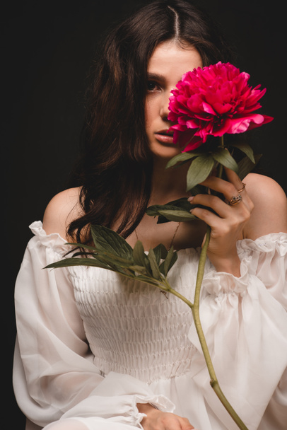 portrait of a young, beautiful and sensual woman with 1 red peony flower in her hands - Foto, Imagem