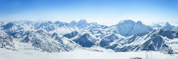 Snowy Greater Caucasus ridge with the Mt. Ushba at winter sunny day. View from Pastuchova kliffs at Elbrus ski slope, Kabardino-Balkaria, Russia - Фото, зображення