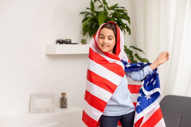 Patriotic holiday. Happy kid, cute little child girl with American flag. USA celebrate 4th of July. - Photo, Image