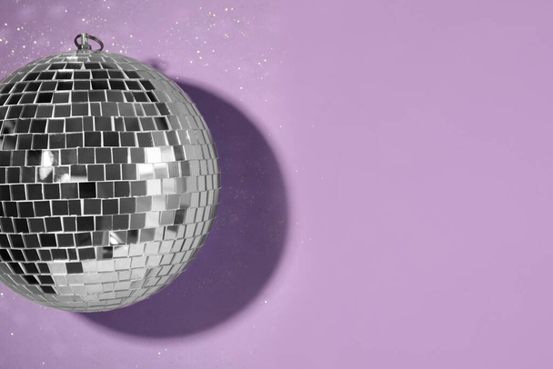 Bright shiny disco ball on violet background, top view. Space for text - Zdjęcie, obraz