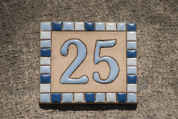 Square faience enamelled decorated plate of number of street address with number 25 closeup - Photo, Image