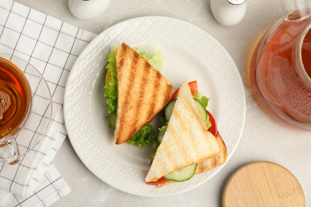 Delicious sandwiches with vegetables and cheese on light grey table, flat lay - Photo, image