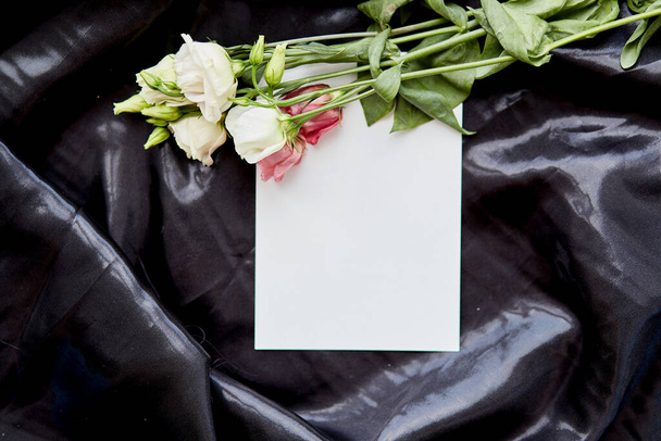 Элегантная бумажная карточка с цветами эустомы на черном фоне. Праздничный творческий макет. Открытка на день рождения или рекламное место. Высокое качество фото - Фото, изображение