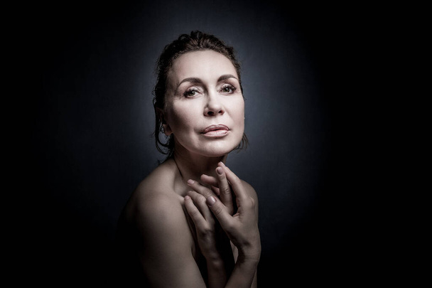 retrato de uma sensual mulher de cinquenta anos em fundo estúdio cinza - Foto, Imagem